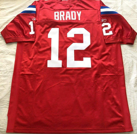 Red football jersey number 12 with BRADY on back, blue and white sleeve stripes