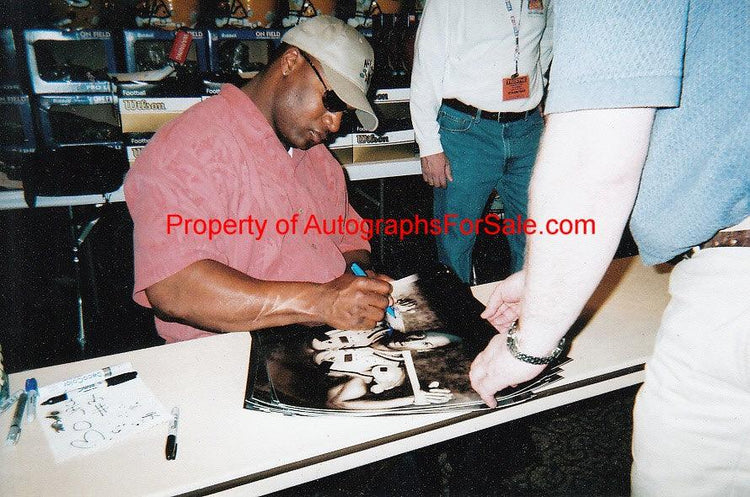 Athlete signing memorabilia at autograph convention booth, AutographsForSale.com event