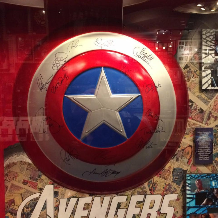 Captain America shield with multiple autographs, Avengers memorabilia display, authentic signed collectible
