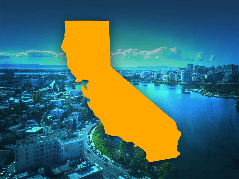 Bright orange silhouette of California state over a cityscape with river and skyline under a blue sky