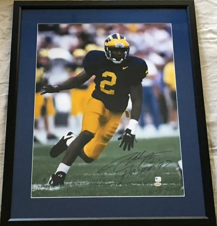 Framed autographed photo of Michigan football player in yellow and blue uniform, signed collectible