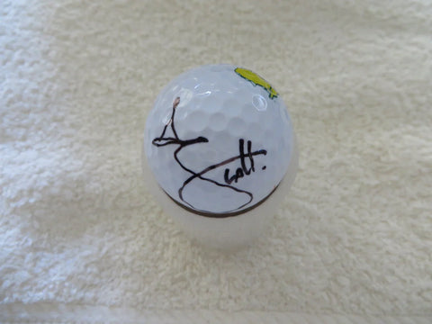 Signed golf ball with black signature and Masters logo on a white towel background