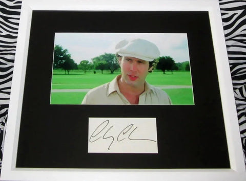 Framed photo of man in white hat on golf course with autograph display, movie memorabilia
