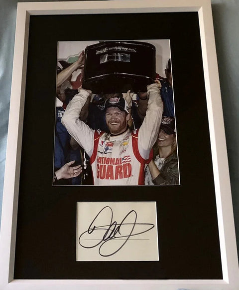 Framed race car memorabilia with winning driver photo and autograph, Daytona 500 trophy.