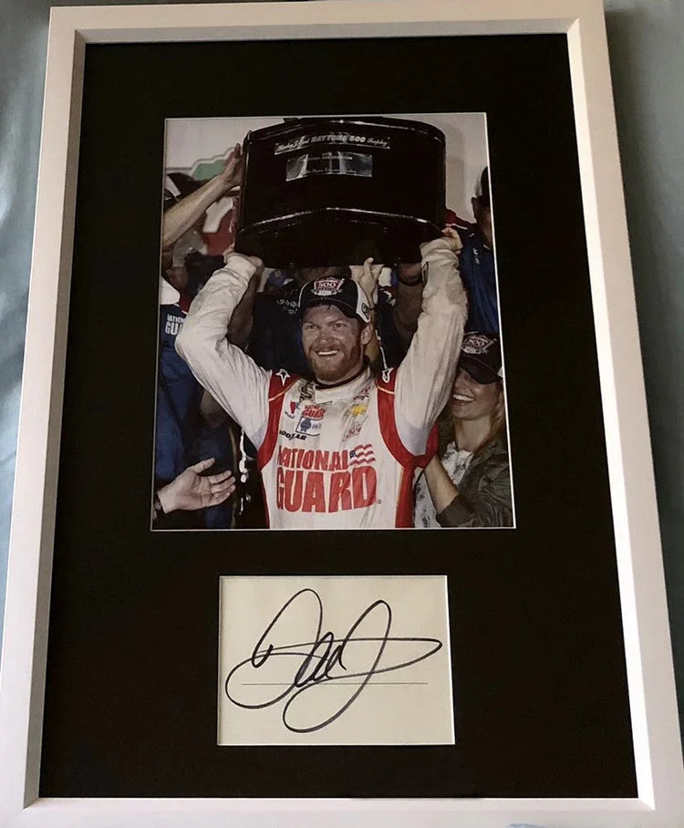 Framed race car memorabilia with winning driver photo and autograph, Daytona 500 trophy.