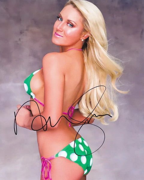 Blonde woman in green polka dot bikini posing, autograph across image, gray studio background