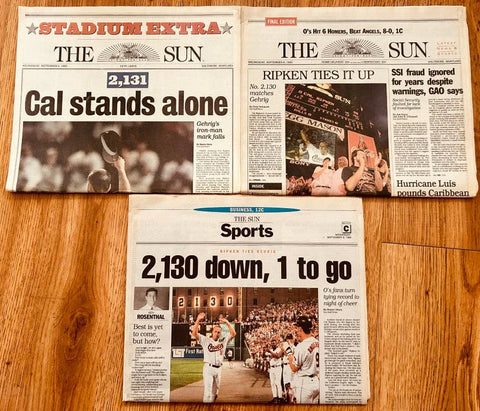 Vintage newspapers featuring Cal Ripken Jr. MLB record streak headlines on a wood floor