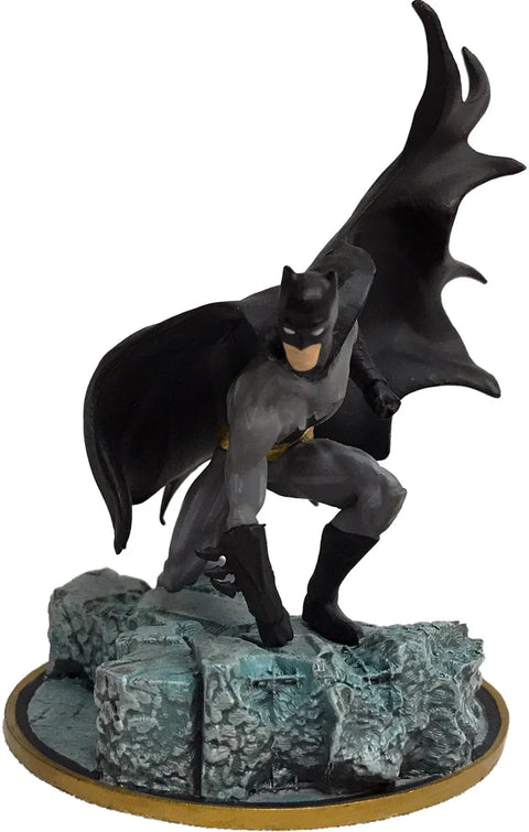 Batman collectible figurine crouching on rocky base, superhero movie memorabilia