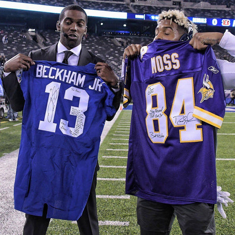 Two men on a football field holding autographed Beckham Jr. and Moss vintage NFL jerseys