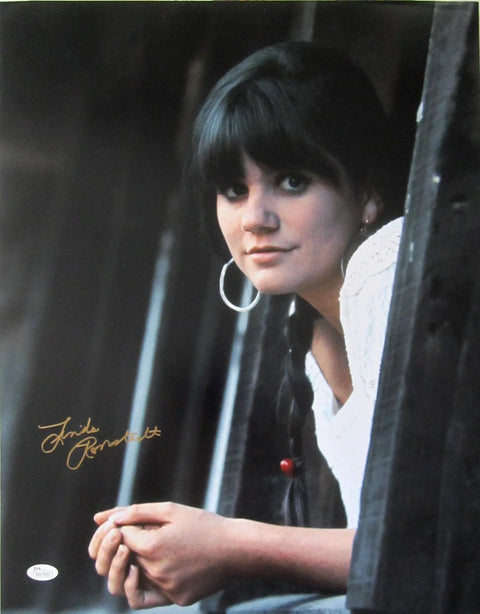 Autographed photo of female musician with long dark hair and hoop earrings