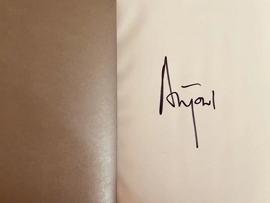 Brown and cream pages with black handwritten signature on cream side