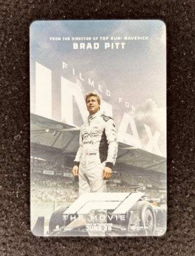 Limited edition IMAX F1 movie promo card featuring racing suit driver at racetrack, Brad Pitt name, collectible memorabilia.