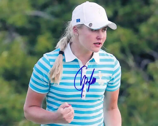 Autographed photo of female golfer in striped polo and white cap, signature visible on chest