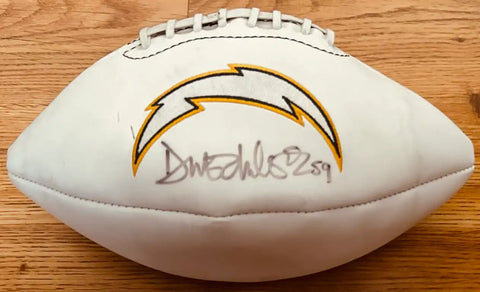 Autographed Los Angeles Chargers football with signature, NFL memorabilia on wood surface