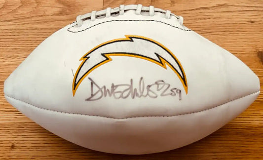 Autographed Los Angeles Chargers football with signature, NFL memorabilia on wood surface