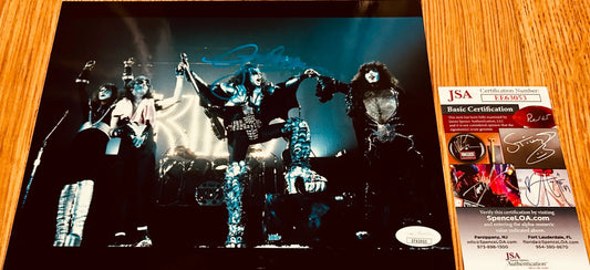 KISS band signed photo with JSA authentication, featuring iconic stage costumes and autographs.