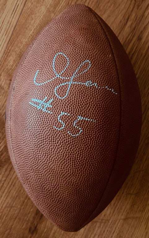 Official NFL football with silver autograph and number 55 on wood floor
