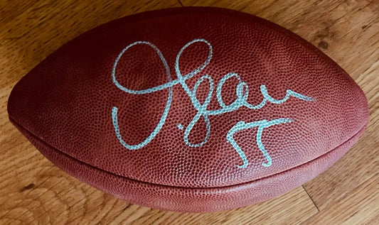 NFL football with blue autograph and player number on wooden floor