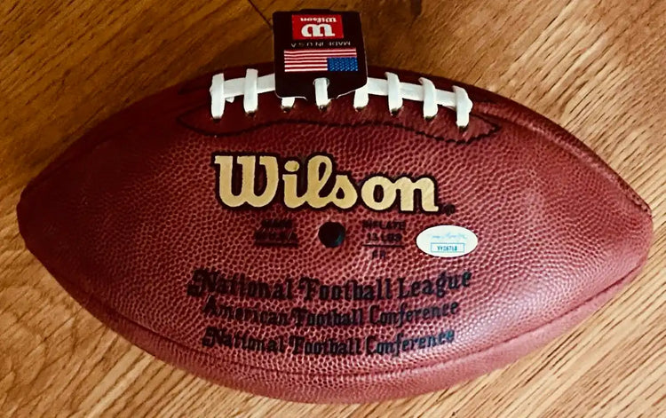 Official Wilson NFL football with laces and certification sticker on wood floor