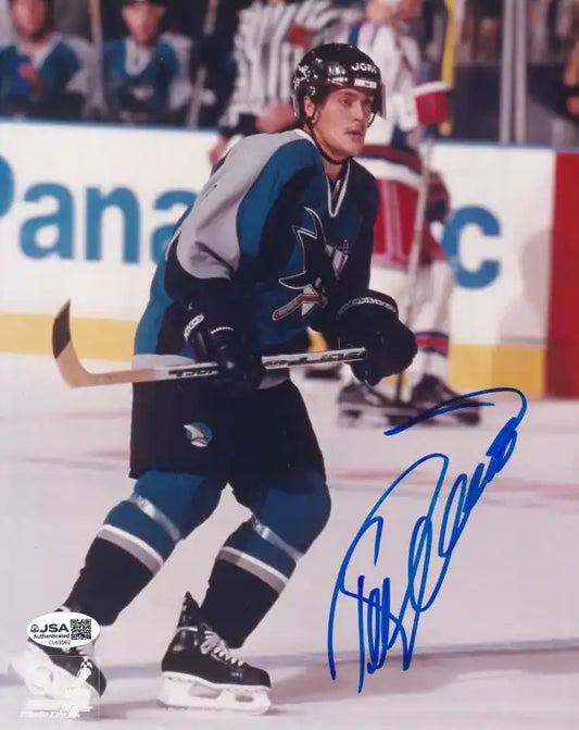 Signed NHL hockey photo of player in teal and black Sharks jersey on ice, authentic autograph with JSA COA