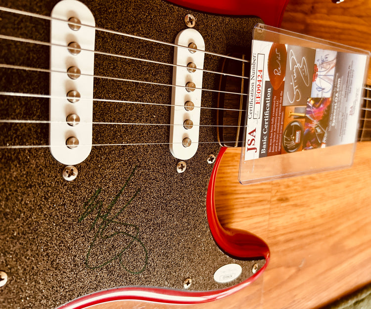 Signed red electric guitar with JSA authentication, featuring autograph on pickguard and certification card.