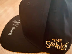 The Sandlot cap with embroidered logo and visible white autograph on the brim
